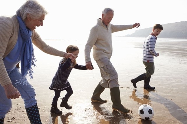 Grandparents playing with their grandchildren on the beach